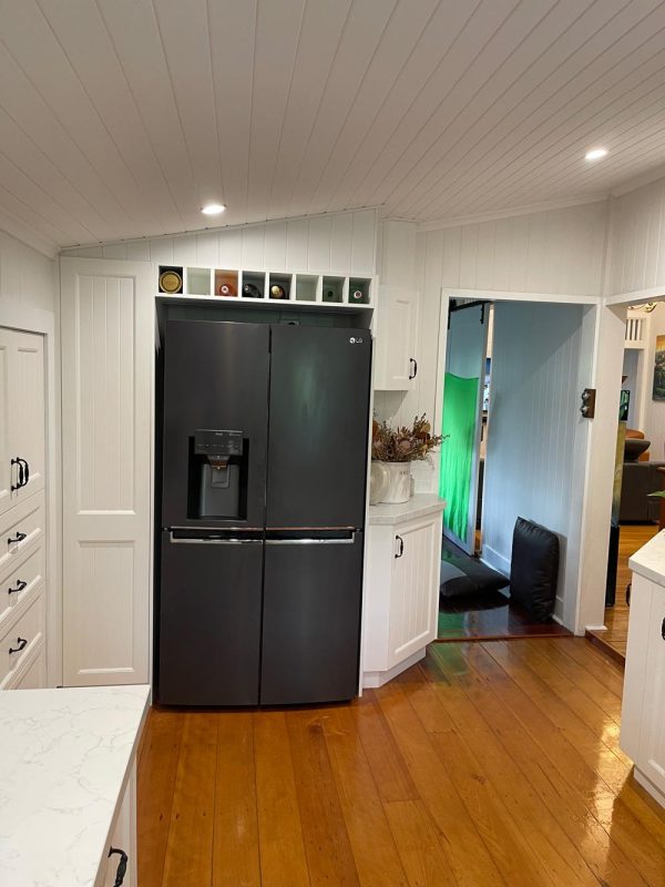 White kitchen with black farmers sink, wine rack installed by kitchen builder Gecko Kitchens in Kedron, Brisbane.