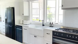 White kitchen with black and white appliances with a white Farmhouse twin sink. Designed and built by Gecko Kitchens in Kedron, Brisbane.