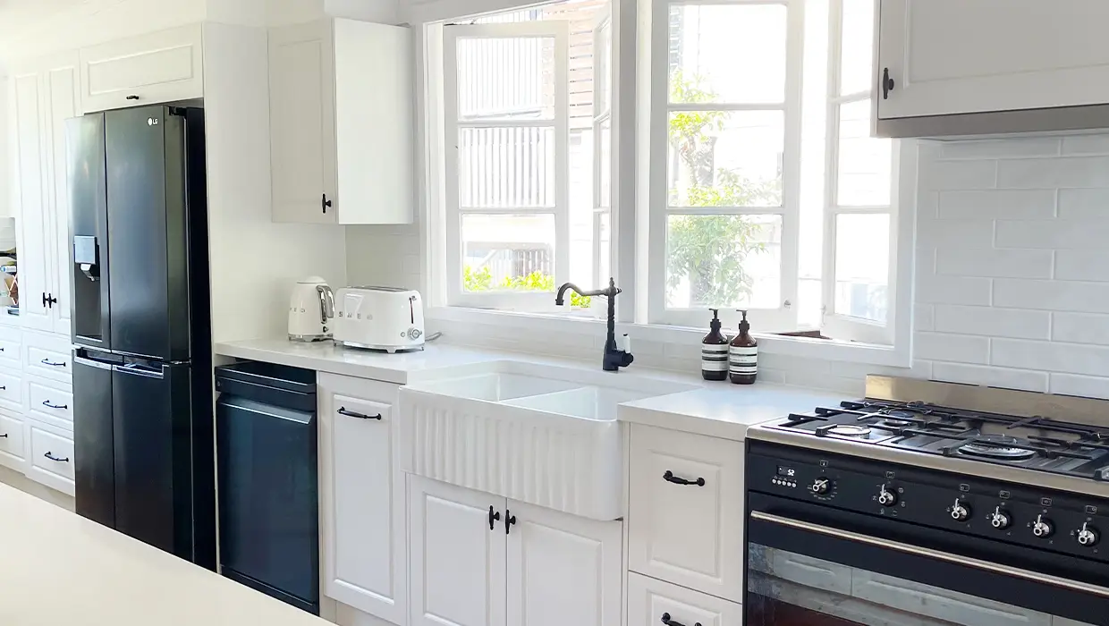 White kitchen with black and white appliances with a white Farmhouse twin sink. Designed and built by Gecko Kitchens in Kedron, Brisbane.
