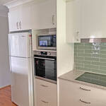 Modern kitchen renovation with white cabinetry, cool green tiles and elegant stone benchtop by Gecko Kitchens,