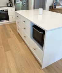 Custom kitchen island bench with white cabinetry designed and installed by Gecko Kitchens, kitchen builder.