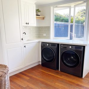 Laundry renovation custom designed by Gecko Kitchens with white cabinetry.