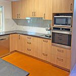 Kitchen built using Polytec Tasmanian Oak Wood Matte and black benchtops by Gecko Kitchens based in Kedron