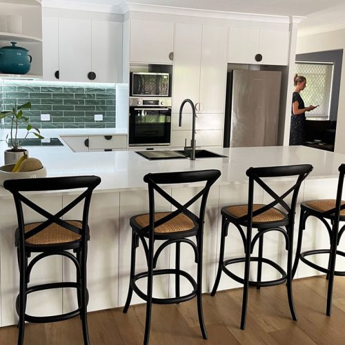 Stone Benchtop with White Cabinetry | Brisbane White kitchen renovation in Brisbane with stone benchtop, metallic-finish half-moon handles and teal green tiles