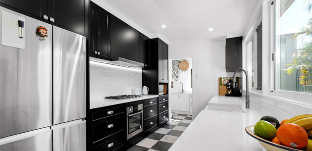 Polytec Thermolaminated Matt Black doors in the elegant Casino profile Polytec Thermolaminated Matt Black doors in the elegant Casino profile, paired with sleek YDL Shadow Grey benchtops, and a modern farmhouse butler sink