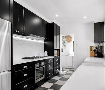 Polytec Thermolaminated Matt Black doors in the elegant Casino profile, paired with sleek YDL Shadow Grey benchtops, and a modern farmhouse butler sink