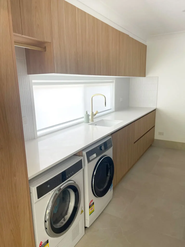 Beautiful Laundry renovation with hanging space, ample storage, and loads of bench space. Gecko Kitchens did this job for Reno Revival builders. 