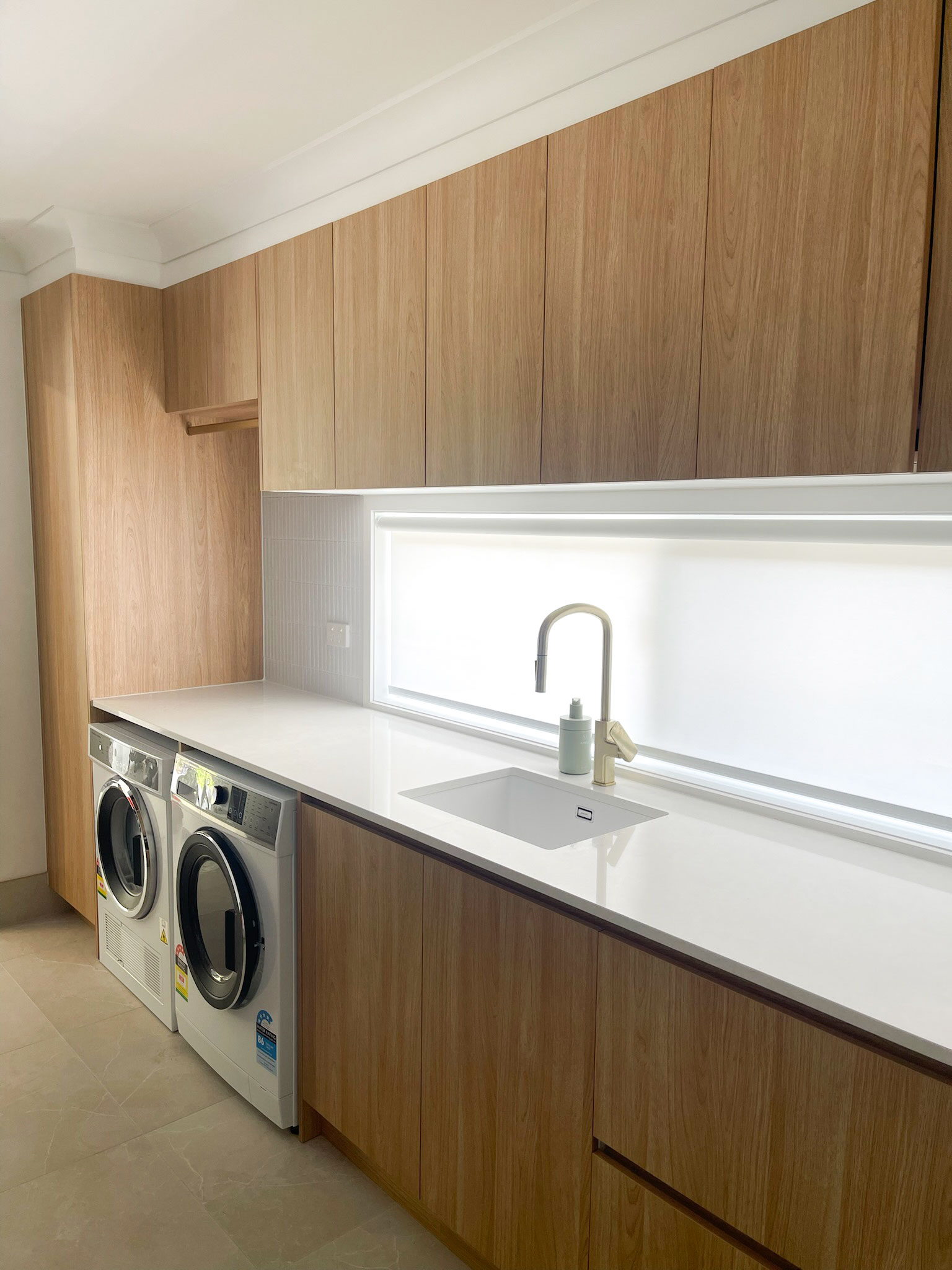 Laundry renovation with hanging space, ample storage, loads of bench spaced. Gecko Kitchens did this job for Reno Revival builders.